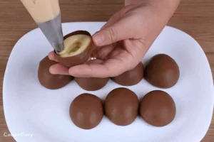Filling chocolate eggs with cream filling
