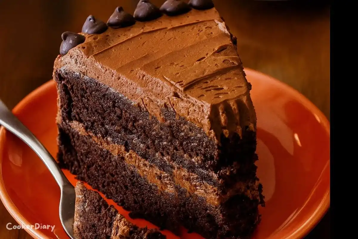 Slice of rich, moist double chocolate cake with glossy chocolate frosting on a white dessert plate