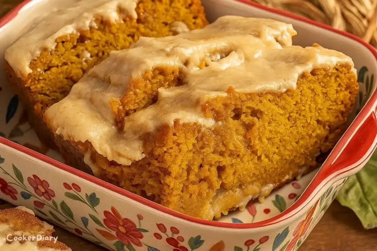 Slice of pumpkin bread drizzled with brown butter maple icing on a plate