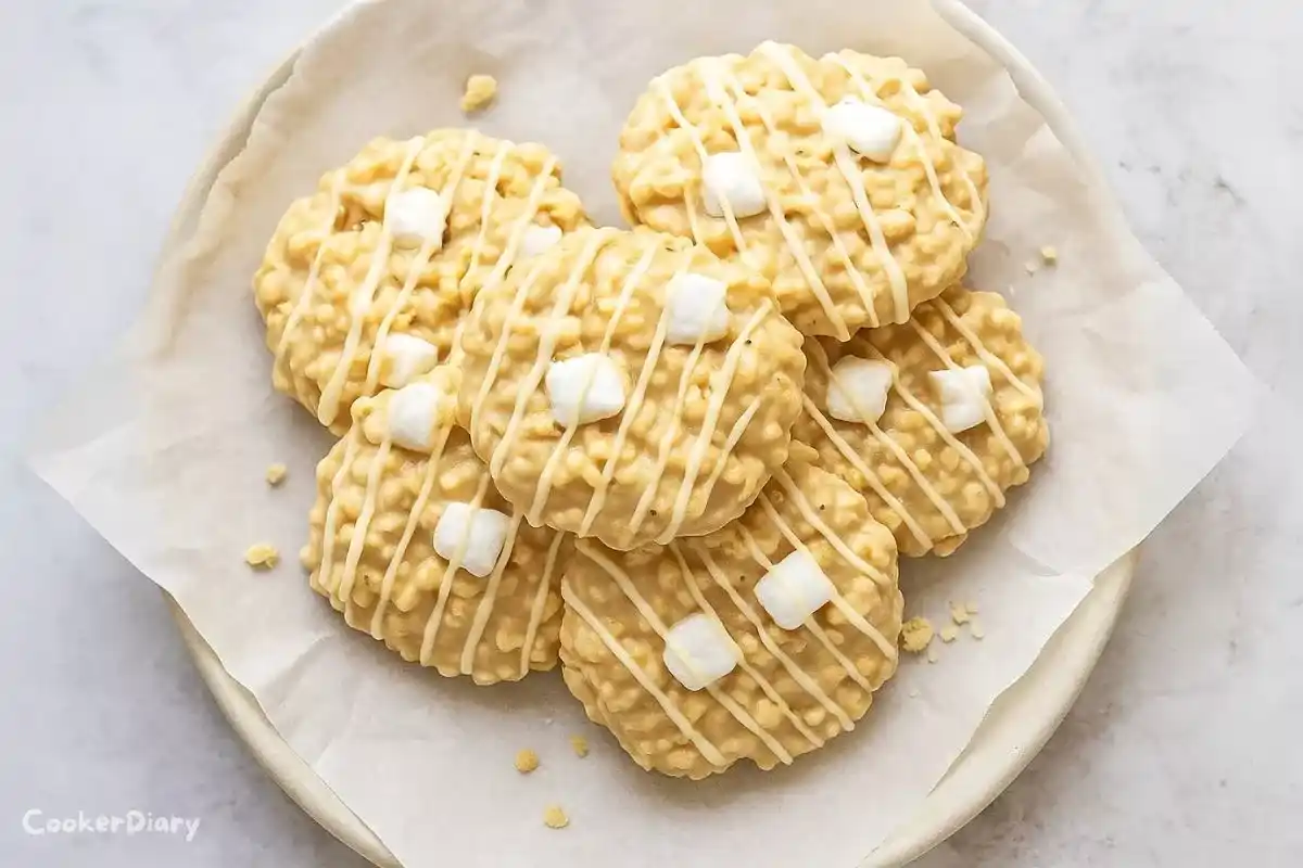 Avalanche cookies stacked on a plate, showing chunks of Rice Krispies, white chocolate, and peanut butter in a creamy, textured bite.