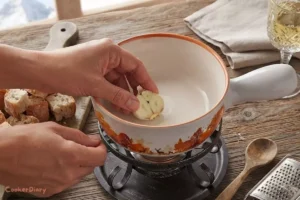 Rubbing garlic inside a ceramic fondue pot